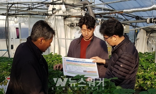 강진서 제작한 ‘딸기재배력’을 농민에게 설명하고 있다.