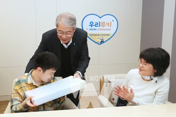 우리금융그룹 우리금융미래재단은 지난 2일 우리금융 본사에서 "우리 루키(Look & Hear) 프로젝트"를 통해 시·청각 수술비를 지원받은 수혜자와 가족 12명을 초청해 새해맞이 행사를 가졌다. 임종룡 우리금융그룹 임종룡 회장(가운데)이 초청 가족에게 선물을 전달하고 있다.