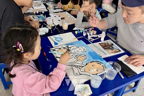 광양제철소 글램핑 행사에 참여한 직원과 자녀가 가족사진 팝아트를 만들고 있다