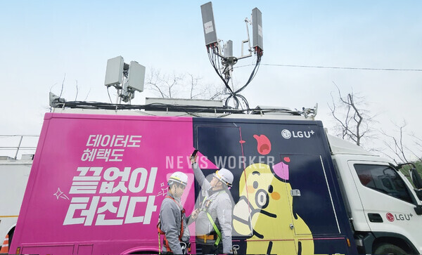 여의도 봄꽃축제에 앞서 LG유플러스 임직원이 이동차량 기지국 앞에서 네트워크를 점검하는 모습