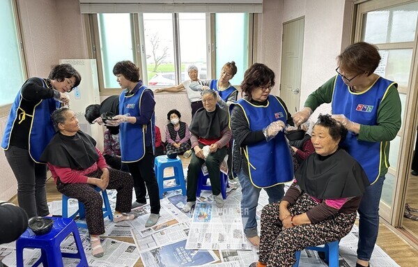 한국여성농업인강진군엽합회 회원들이 강진읍 초동마을에서 어르신들의 머리를 염색하고 있다.