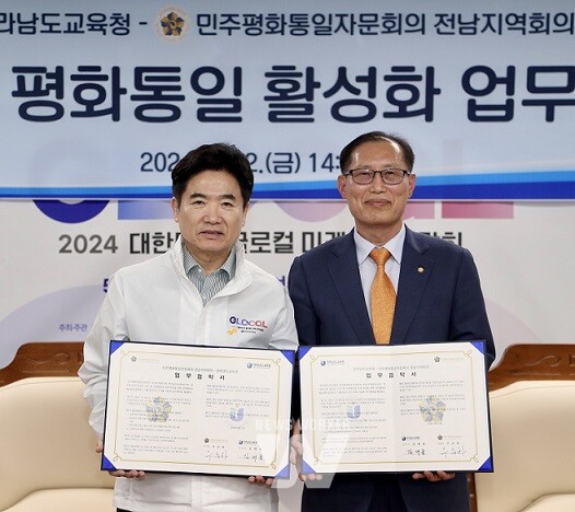 김대중 전남교육감(왼쪽)과 우승하 민주평화통일자문회의 전남지역회의 부의장이 12일 전남교육청 비즈니스실에서 열린 업무협약식을 마친 뒤 기념촬영을 하고 있다.