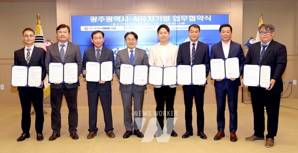 강기정 광주광역시장이 29일 오후 시청 3층 비즈니스룸에서 열린 ‘인공지능 유치기업 업무 협약식’에 참석해 협약서에 서명한 뒤 기념촬영을 하고 있다./ 광주광역시 제공