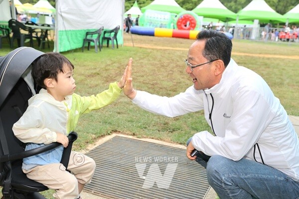 명현관 해남군수가 해남공룡박물관을 찾은 어린이와 하이파이브를 하고 있다.