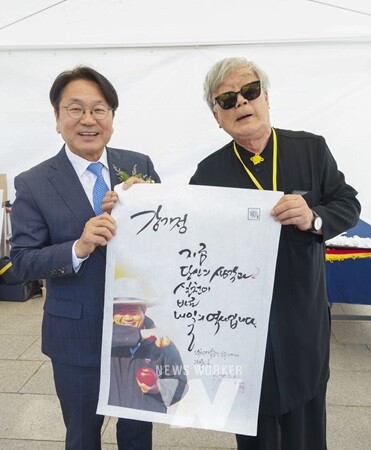 강기정 광주광역시장이 20일 오전 동구 국립아시아문화전당 플라자브릿지에서 열린 ‘고 노무현 전 대통령 서거 15주기 추모 사진전 개막식’에 참석해 명계남 배우에게 선물받은 ‘노무현 어록 명계남 캘리그라피’를 들고 있다./광주광역시 제공