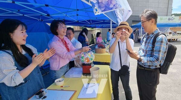 골목상권 이벤트 응모와 체험을 위해 방문객이 우중에도 대기 중이다.