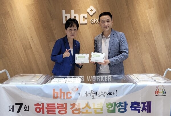 bhc 치킨이 '제7회 허들링 청소년 합창 축제'에 치킨을 기부하는 전달식을 가진 후, bhc 아카데미 한성민 팀장(우측)과 서울시 문전자 봉사단장이 기념 촬영을 하고 있다.