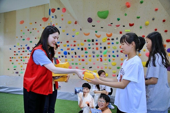 광주신세계, 봉사단이 지역 아동에게 준비한 간식박스를 나눠주고 있다.