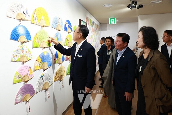 류현자 작가가 관람객과 구복규 화순군수에게 작품을 설명하고 있다.