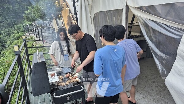 광양제철소가 진행한 1박2일 글램핑 행사에서 직원과 자녀들이 야외에 삼삼오오 모여 고기를 구워 먹고 있다