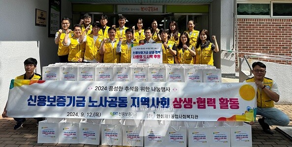 이성주 신용보증기금 전무이사(첫 줄 오른쪽에서 다섯 번째), 소병화 노동조합 수석부위원장(첫 줄 오른쪽에서 세 번째), 이기일 안심제1종합사회복지관장(첫 줄 오른쪽에서 네 번째)과 신보 직원들이 추석맞이 노사공동 지역 상생 사회공헌활동에 참여해 기념사진을 촬영하고 있다.