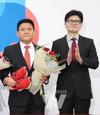 최봉의 후보자가 한동훈 대표로 부터 운동화와 꽃다발을 받고 포즈를 취하고 있다.