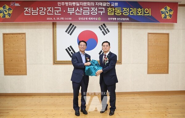 강진원 군수가 박찬원 금정구 협의회장에게 동백생초를 전달하고 있다.