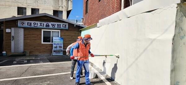 광양제철소 에버그린 벽화 재능봉사단이 벽화를 그릴 바탕색을 칠하는 모습.