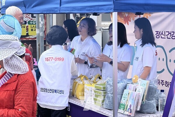 정신건강복지센터 직원이 주민에게 정신건강사업 안내하는 모습