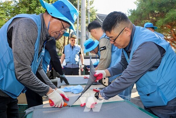 광양제철소 방진망 재능봉사단원들이 칠성노인요양원에 설치할 방충망을 재단하고 있다