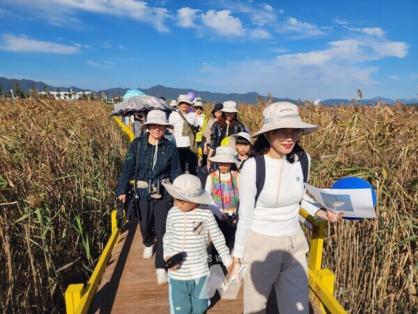 에코가족원정대에 참여한 가족들이 강진만 생태공원 입구에서 기념촬영을 했다. 2. 에코가족원정대에 참여한 가족들이 강진만 생태공원의 갈대밭을 걸으면 즐거운 한 때를 보내고 있다.