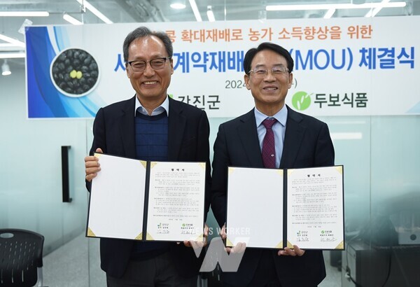 강진원 강진군수(오른쪽)와 허태곤 ㈜두보식품 대표이사가 협약서에 서명한 뒤 기념사진을 찍고 있다.