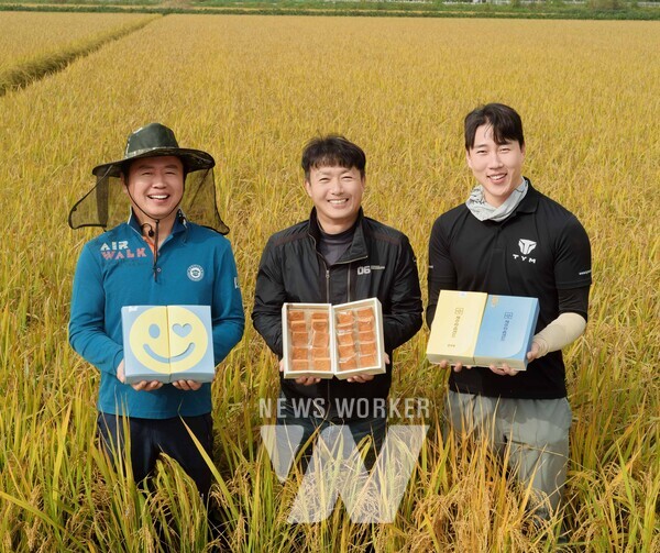 가루쌀 농가에서 농업인들이 가루쌀을 원료로 활용한 파리바게뜨의 샌드쿠키를 들고 기념 촬영을 하고 있다.