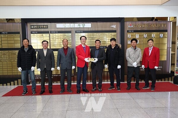 흑산통발협회 회원들과 기탁식 참석자들이 신안군청 명예의 전당에서 현판을 게시하며 기념 촬영을 하고 있다