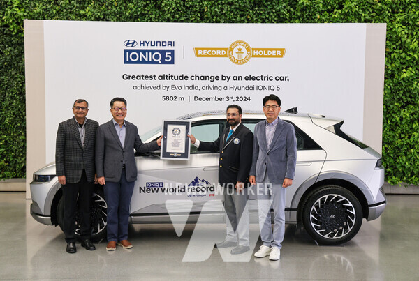 현대자동차 인도아중동대권역장 김언수 부사장(왼쪽 두번째)이 기네스북에 등재된 아이오닉 5를 배경으로 기네스북 인증서를 들고 기념촬영을 하는 모습