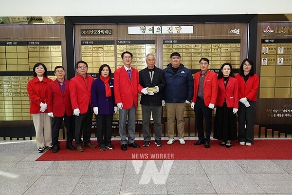 증도면 이평관씨와 이문성씨가 관계자들과 함께 신안군청 명예의 전당에서 현판을 게시하며 기념 촬영을 하고 있다
