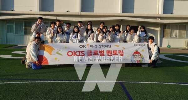 OK배정장학재단의 배정장학생들이 일본 현지 ‘오사카 금강 인터내셔널스쿨’의 인조잔디 운동장에서 기념촬영을 하고 있다. (출처:OK금융그룹)