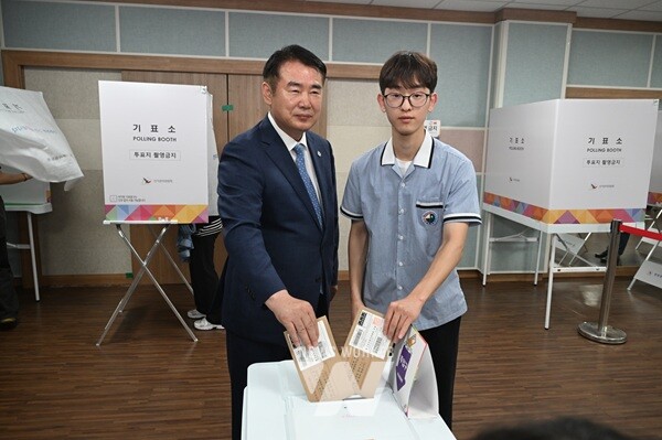 이정선 광주광역시교육감(왼쪽)이 29일 화정2동 행정복지센터에 마련된 투표소에서 생애 첫 투표자가 된 광덕고 하유성 학생회 부회장(오른쪽)과 투표함에 투표용지를 넣고 있다. / 광주광역시교육청 제공