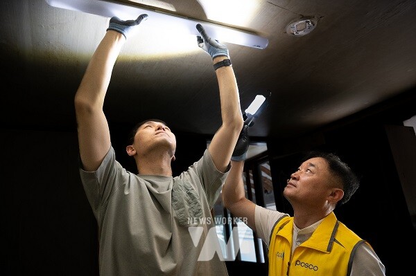 지난 28일, 광양 진월면 차동마을에서 광양제철소 전기재능봉사단이 지역 주민 자택의 전등을 수리하고 있다.