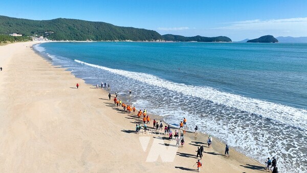 신지 명사십리 해변을 걷는 사람들