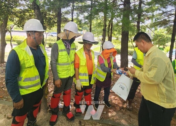 시 관계자가 옥외 현업근로자를 찾아 폭염대비 행동 요령을 안내하고 쿨토시 등 온열질환 예방물품을 전달하고 있다