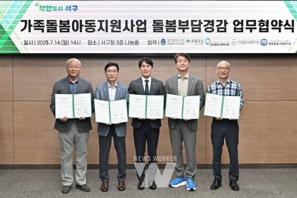 김이강 광주 서구청장이 14일 서구청 나눔홀에서 열린 '초록우산 어린이재단 가족돌봄지원사업 협약식'에서 협약서에 서명한 후 참석자들과 기념촬영을 하고 있다. 광주 서구 제공