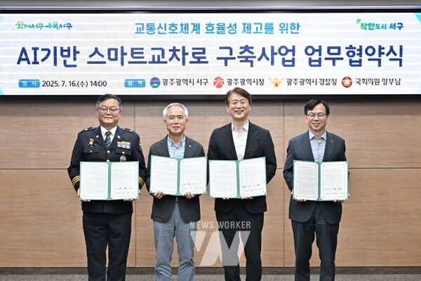 김이강 광주 서구청장이 16일 서구청 이음홀에서 열린 'AI기반 스마트 교차로 구축사업 업무협약식'에서 협약서에 서명한 후 참석자들과 기념촬영을 하고 있다. 광주 서구 제공