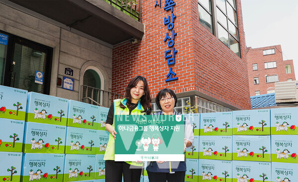 행사에 참석한 하나금융그룹 직원이 김나나 서울특별시립 창신동쪽방상담소장(사진 오른쪽)에게 행복상자를 전달하며 기념촬영을 하고 있다.