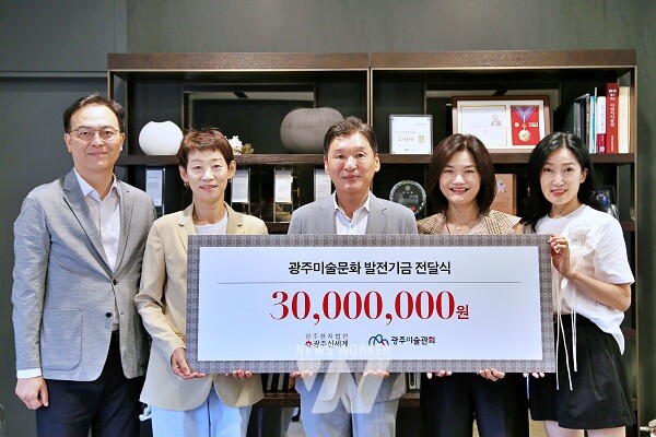 광주신세계가 지역 문화예술 발전을 위해 광주미술관회에 후원금을 전달하고 기념사진을 찍고 있다