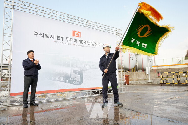 사진= E1 김욱주 여수기지장(오른쪽)이 2024년 3월, 여수기지에서 무재해 40년 달성 기념 깃발을 흔들고 있다
