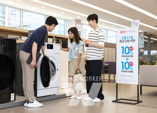 삼성전자 모델이 에너지 소비효율 1등급의 '세탁건조기'와 '에어컨' 제품의 설명을 듣고 있다.