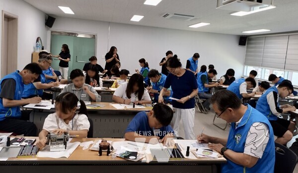 광양제철소 사랑나눔봉사단이 아이들과 쌍사자 석등 키링을 만들고 있다.