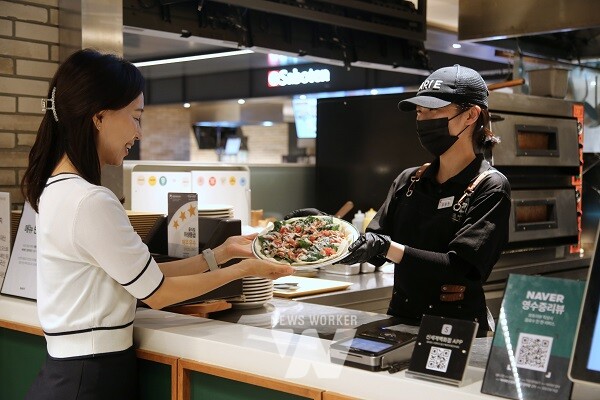 광주신세계 바리에 매장에서 직원이 고객에게 피자를 전달하고 있다