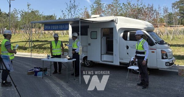 박상형 한전KDN 사장이 OPGW 현장에 설치된 온열질환 대비 이동식 쉼터 앞에서 OPGW공사 개요 등 보고를 받고 있다.