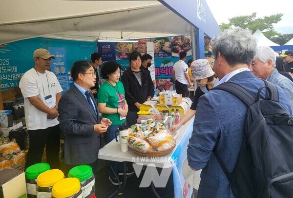 강상구 나주시 부시장(왼쪽)이 나주배 홍보관을 찾은 방문객들에게 시식을 권유하며 나주배 홍보에 열을 올리고 있다.(사진 제공-나주시)